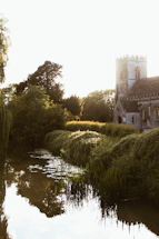 A peaceful church courtyard bathed in soft green light at sunset.