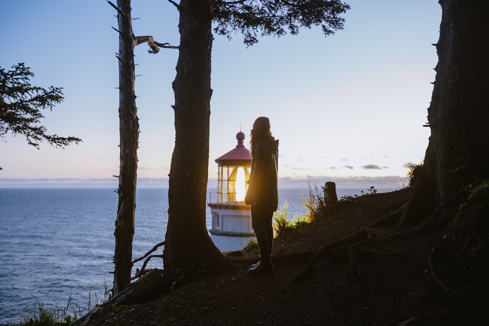 a person standing in front of a light house