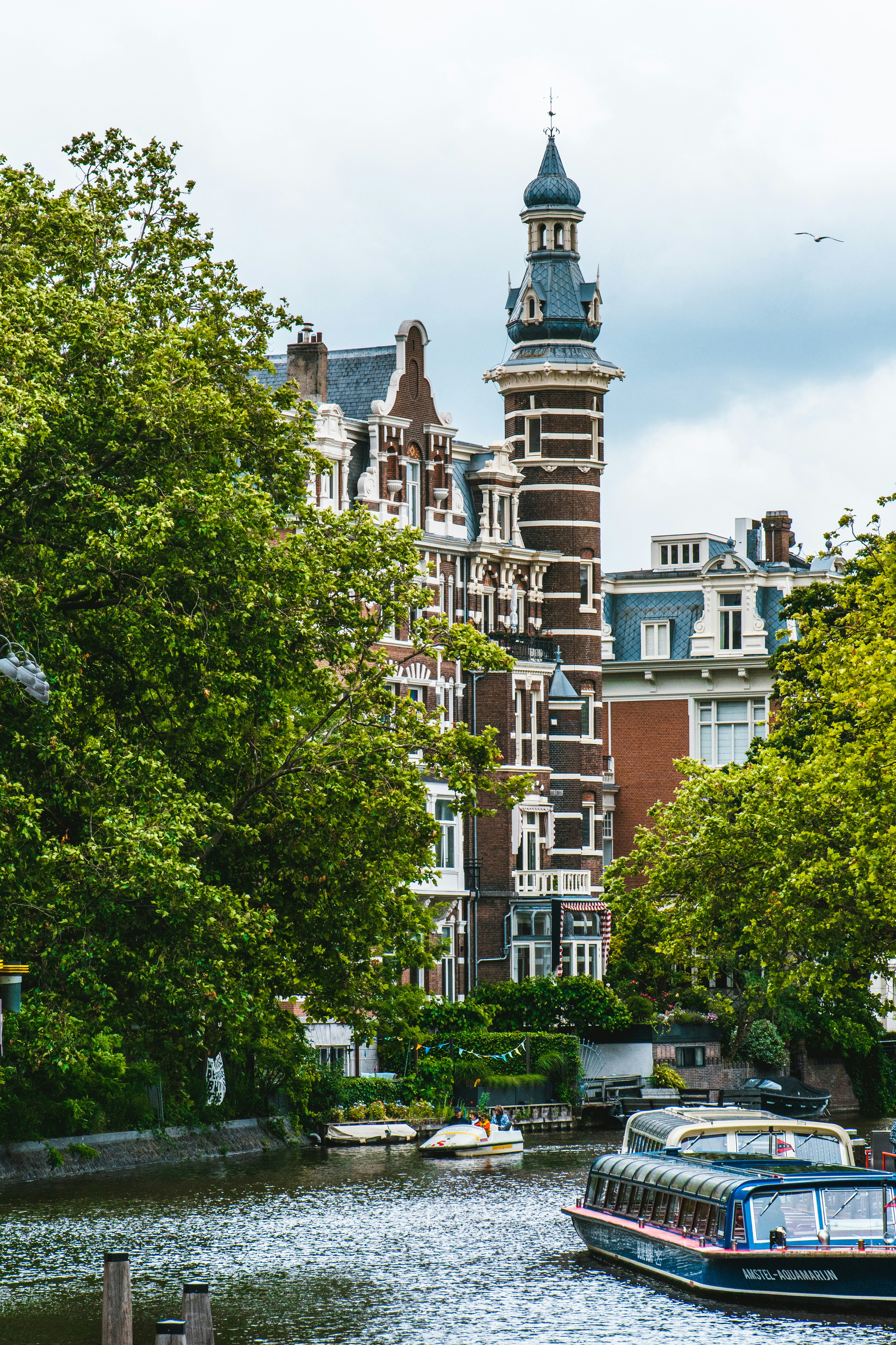 a boat traveling down a river next to tall buildings