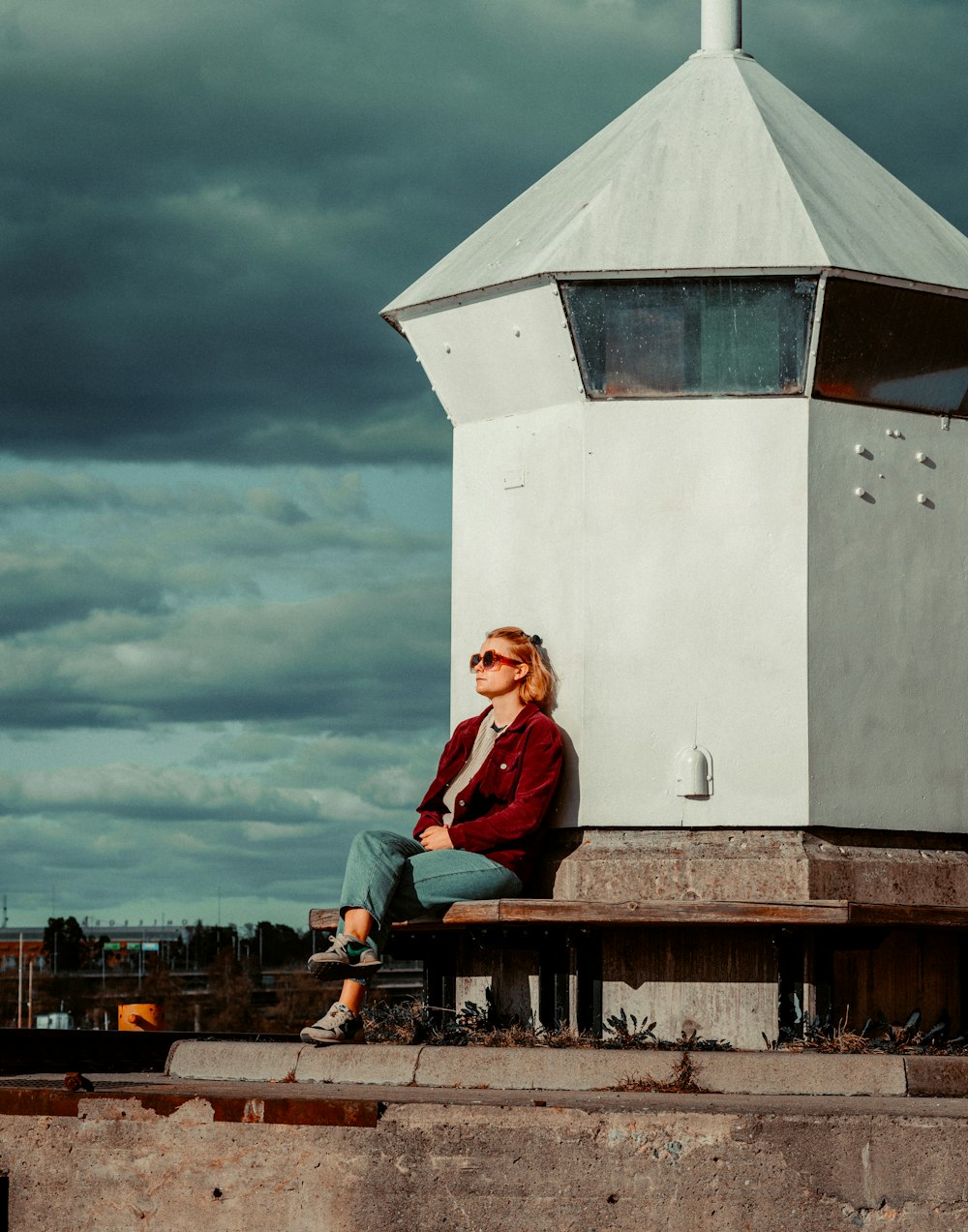 a woman sitting on a bench in front of a tower