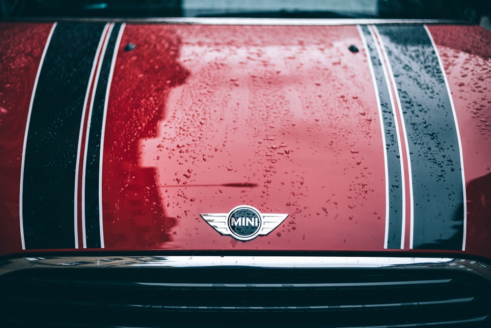 a close up of a red car with rain drops on it