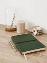 a green notebook sitting on top of a wooden table