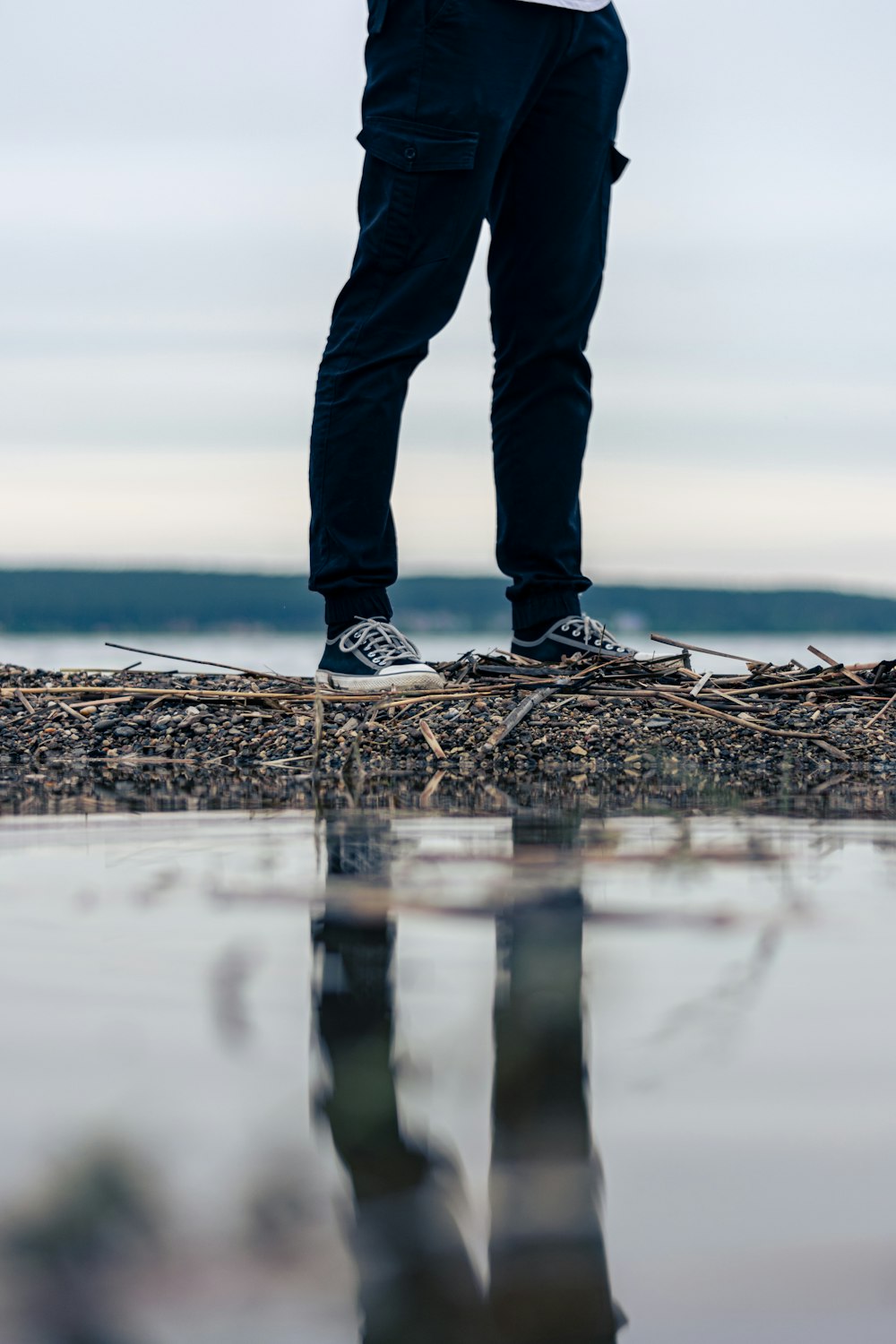 a person standing on top of a beach next to a body of water