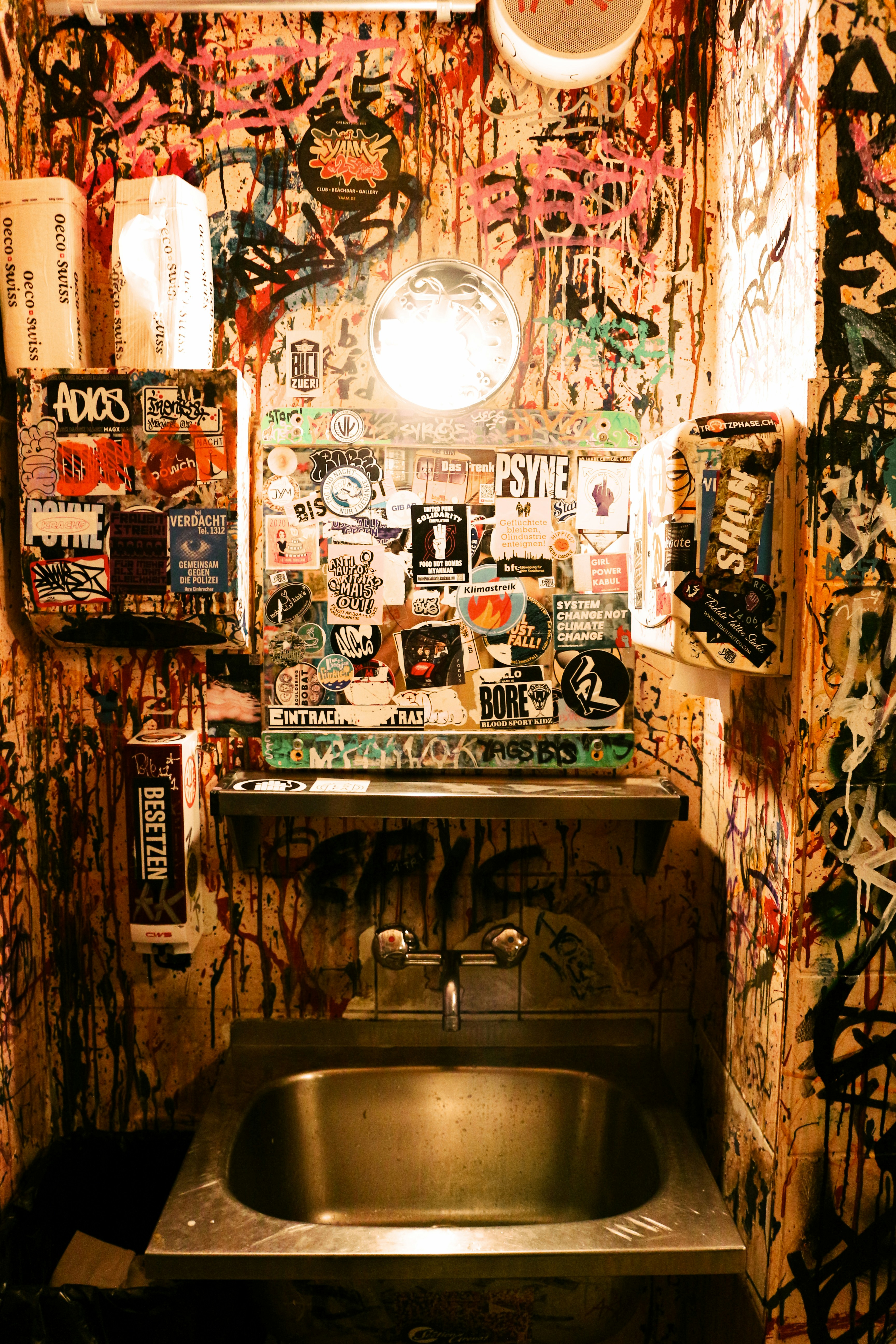 a bathroom with graffiti all over the walls