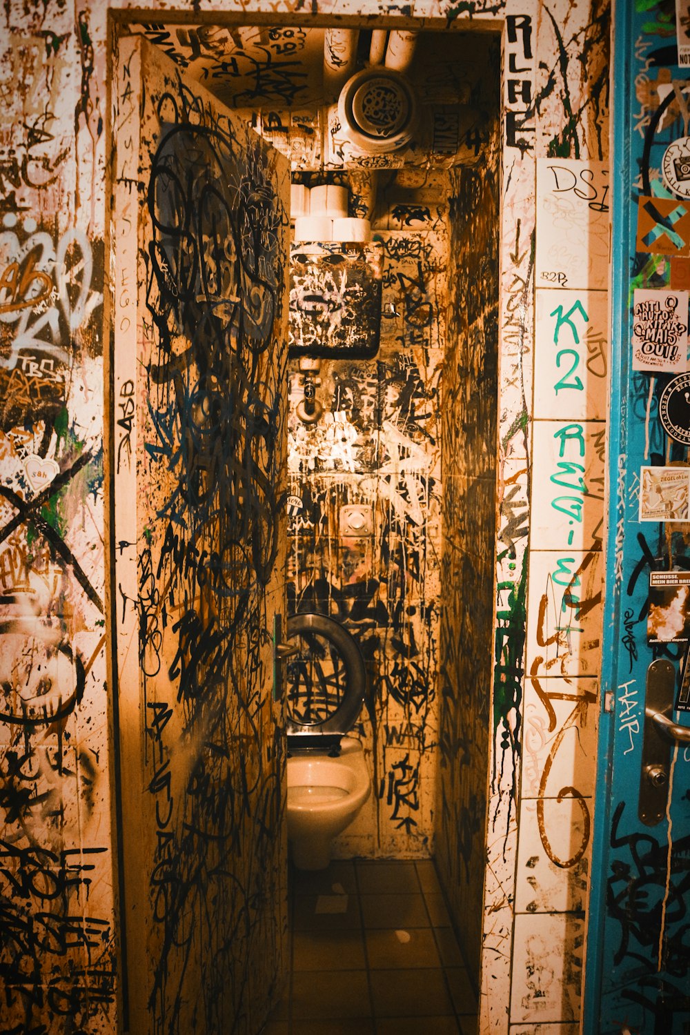 a urinal in a bathroom covered in graffiti