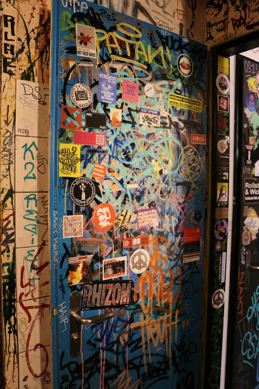 a wall covered in graffiti and stickers