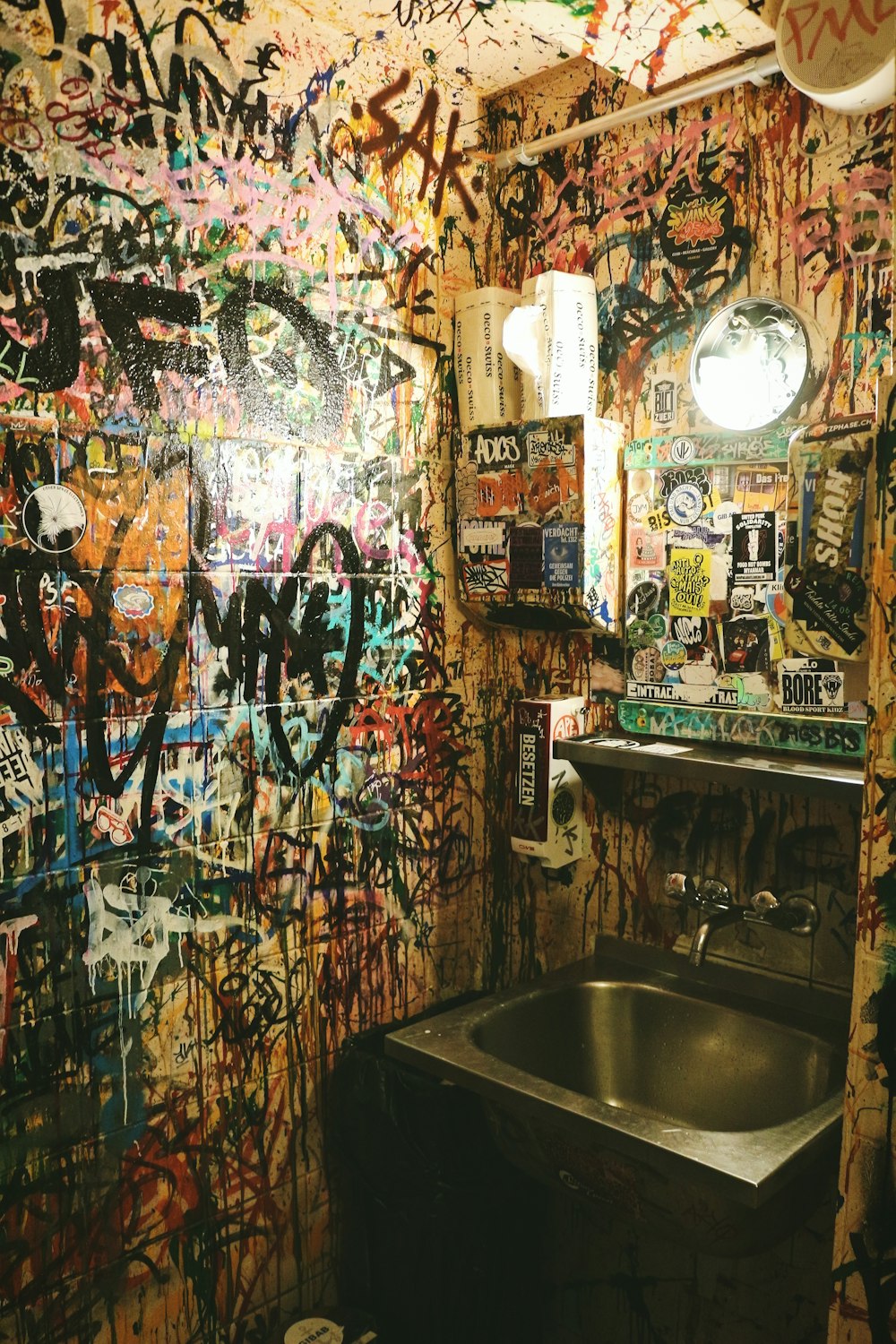 a bathroom with graffiti all over the walls