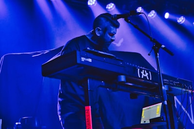 A musician playing keyboard in a gospel band setting with vibrant lighting.
