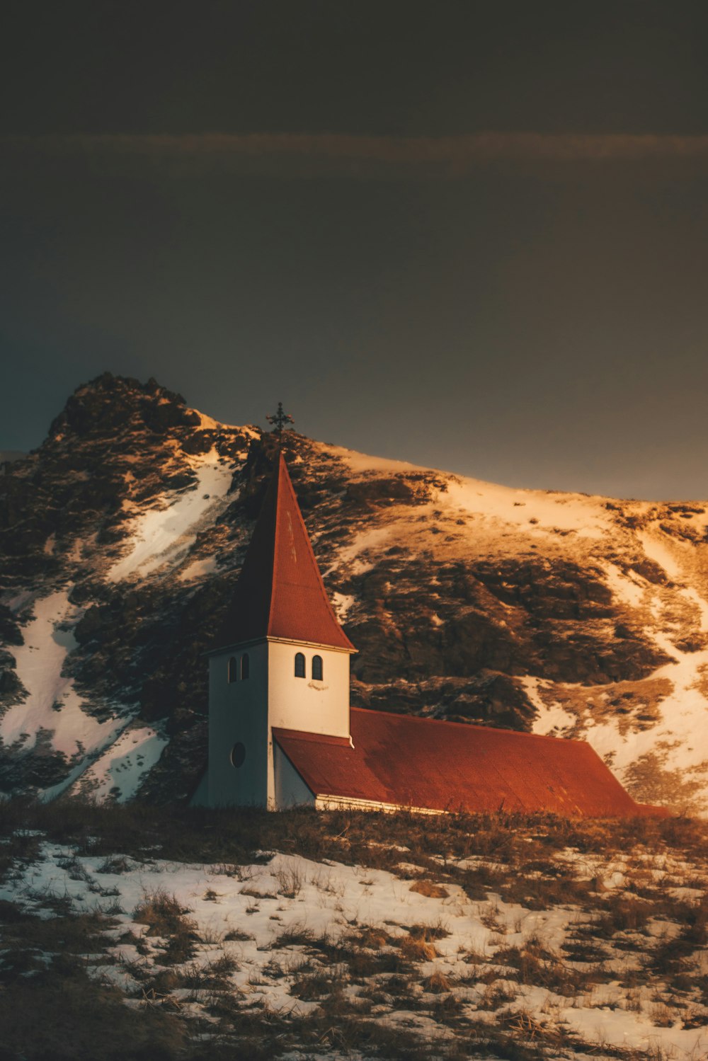 a church on a hill with a mountain in the background