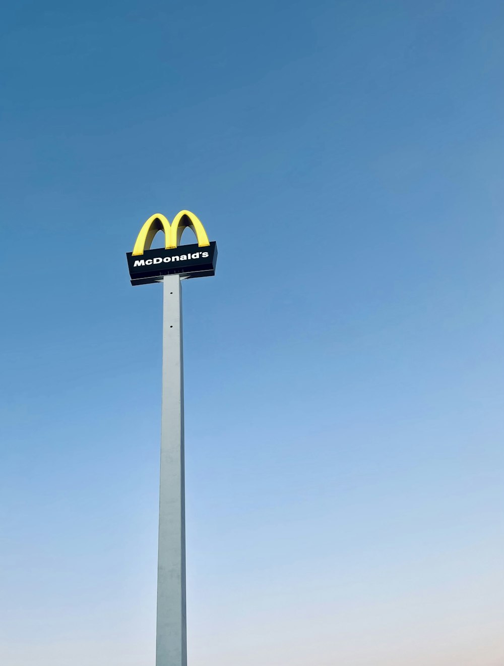 a mcdonald's sign on top of a tall pole
