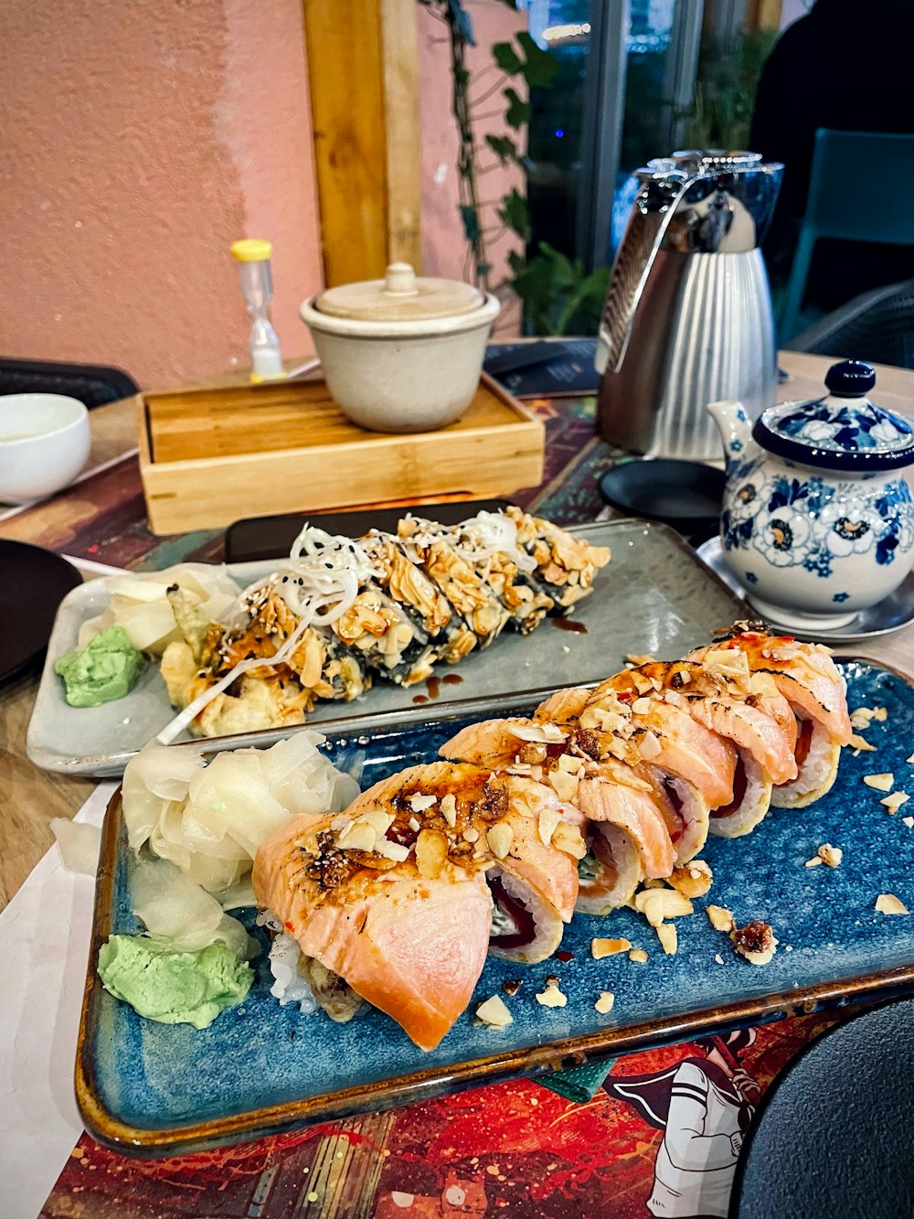 a plate of sushi with chopsticks on a table