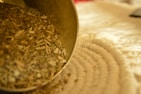 Fresh moringa leaves and powder spilling gently from a rustic bowl.