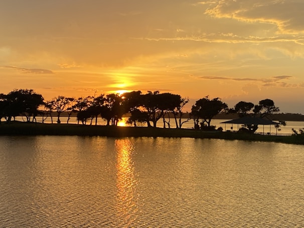 A vibrant sunset over the Taj Mahal with warm golden hues reflecting on the Yamuna River.
