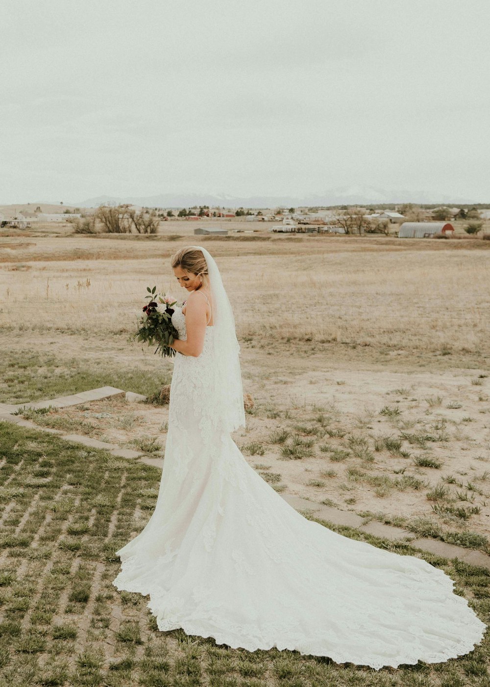a woman in a wedding dress standing in a field