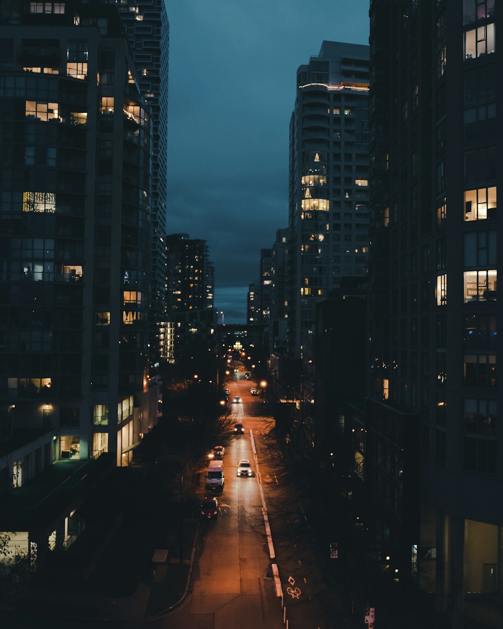 a city street at night with tall buildings