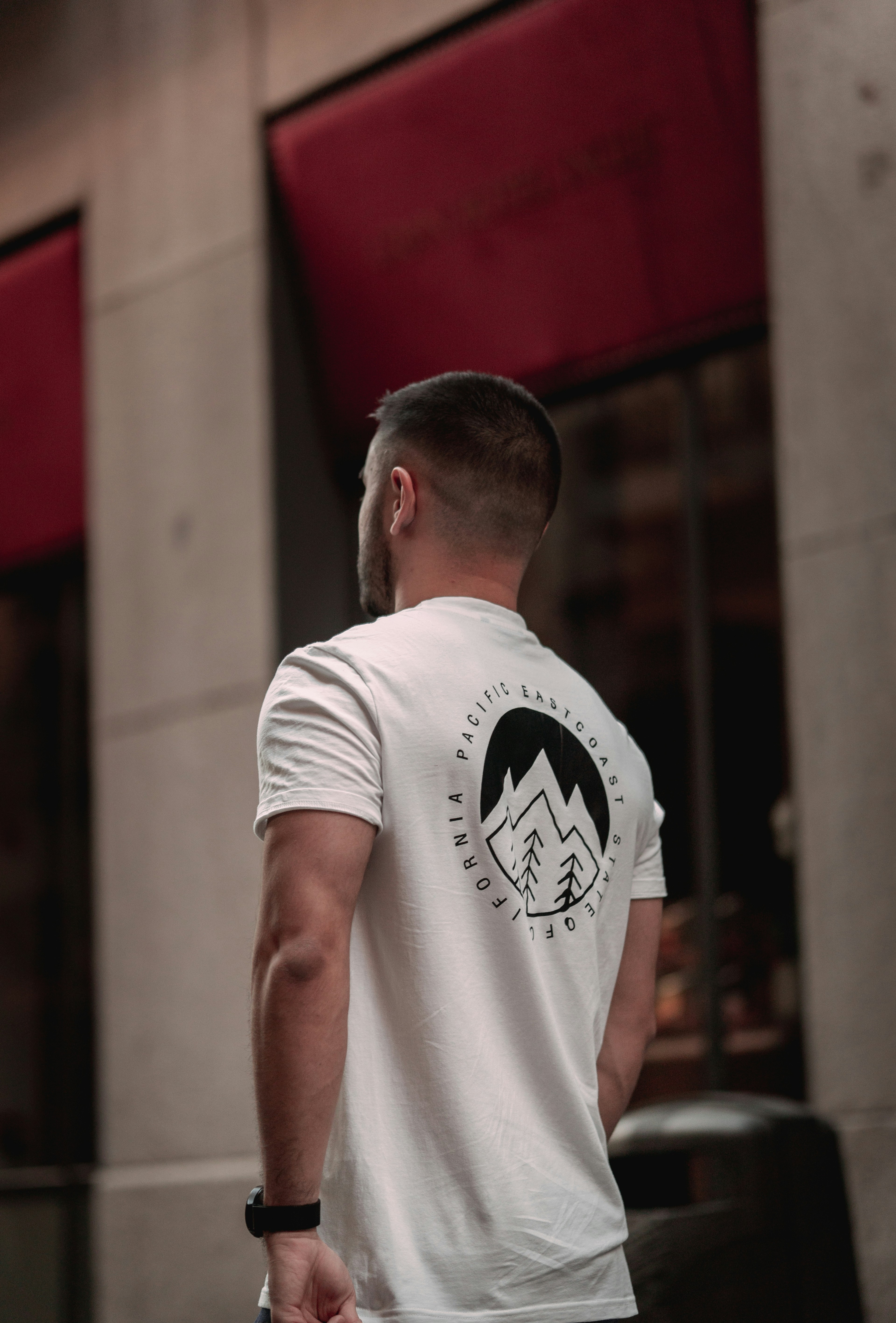 Person wearing dark graphic t-shirt in urban street setting