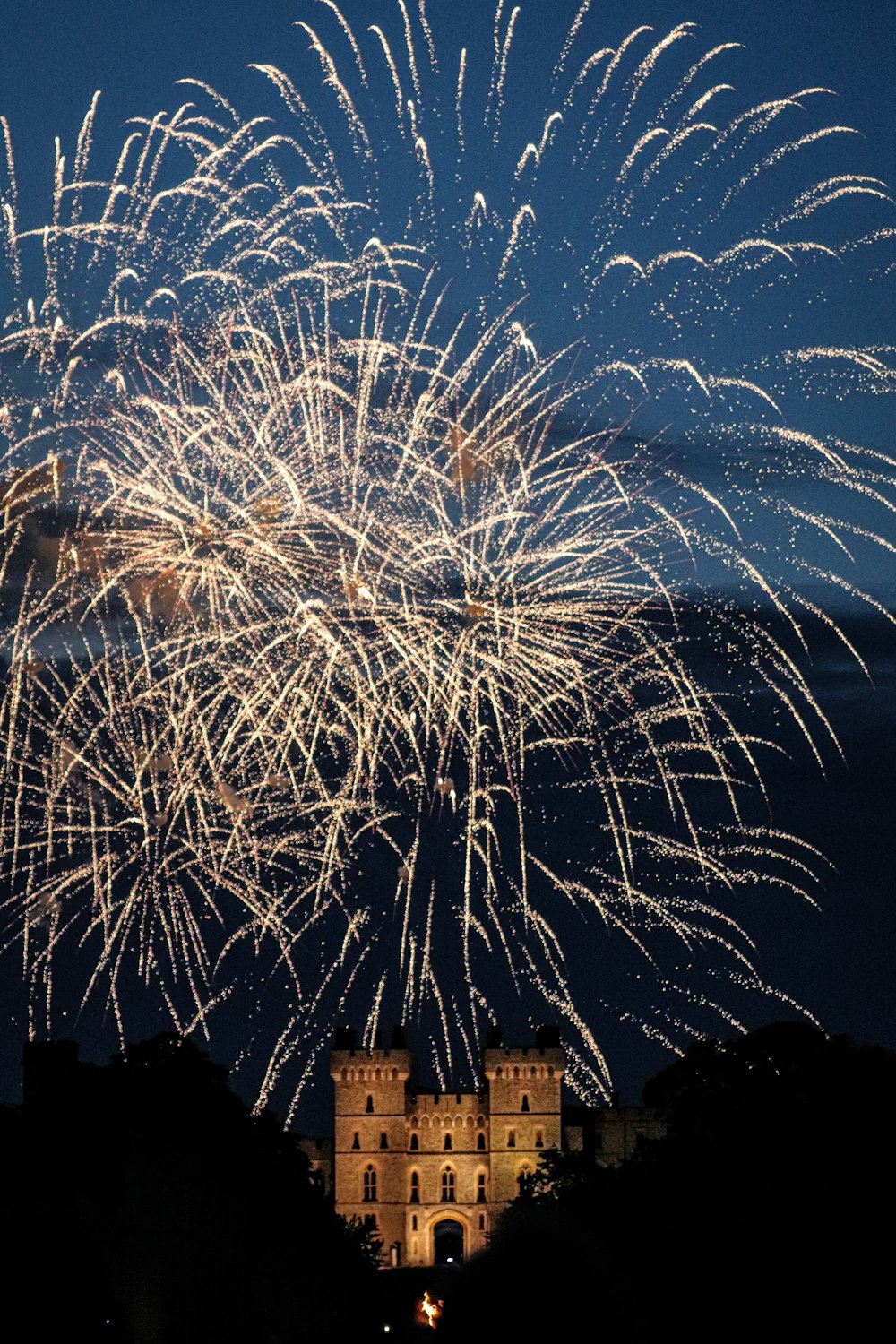 a large fireworks display in the sky above a castle