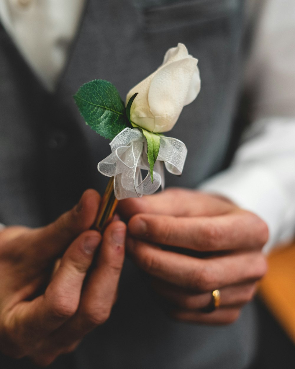 a man is holding a white rose in his hands