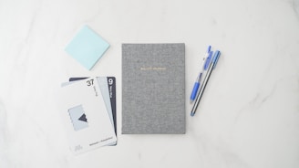 Elegant shot of branded stationery items like diaries, pens, and folders styled with navy and grey tones.