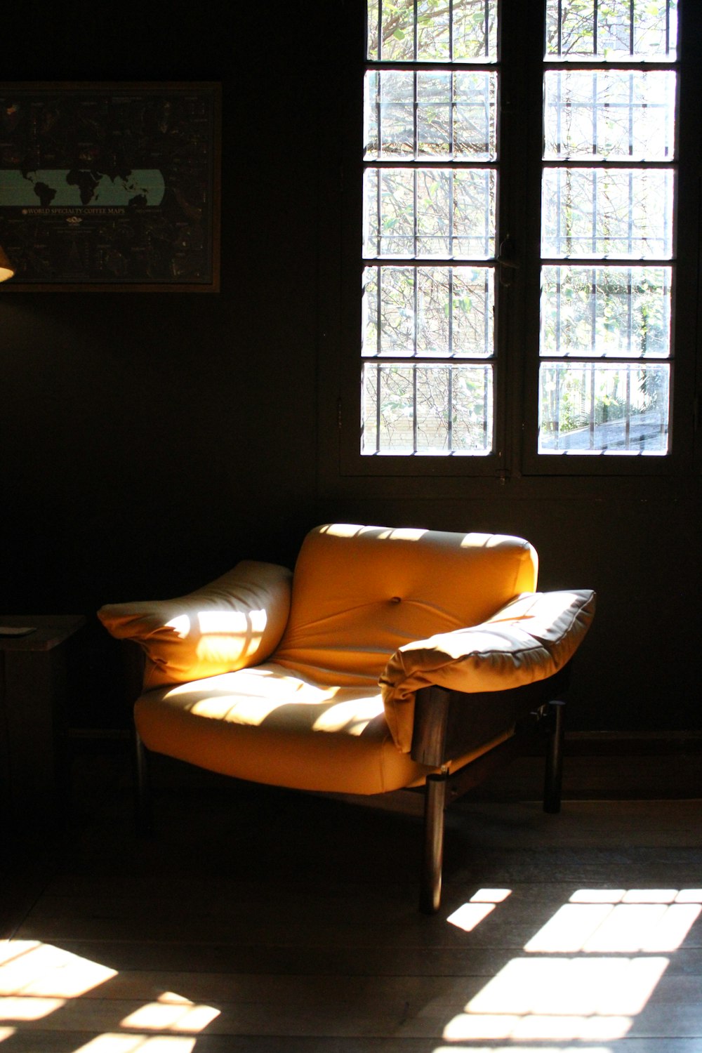 uma cadeira amarela sentada em uma sala escura