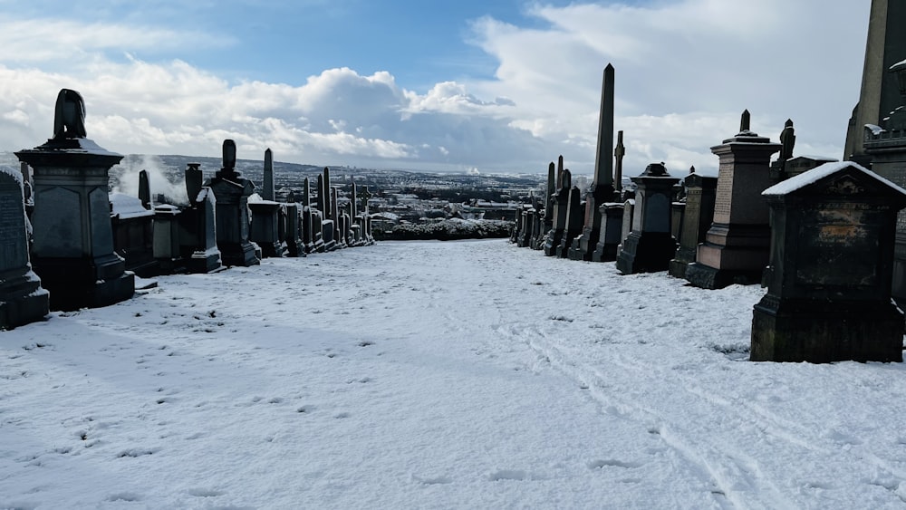 a snow covered cemetery with a blue sky in the background