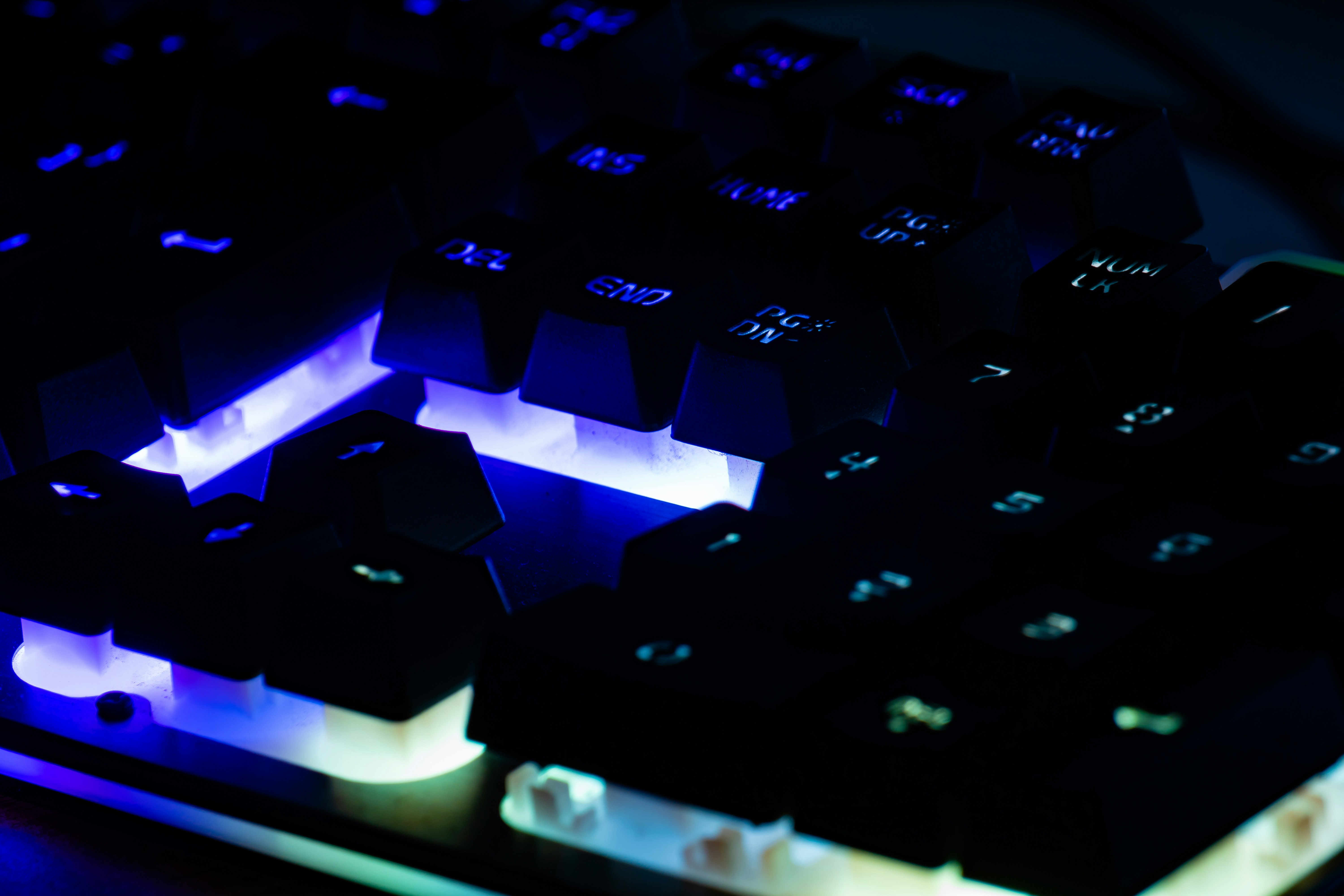 a close up of a computer keyboard with blue lights