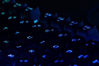 a close up of a blue illuminated keyboard