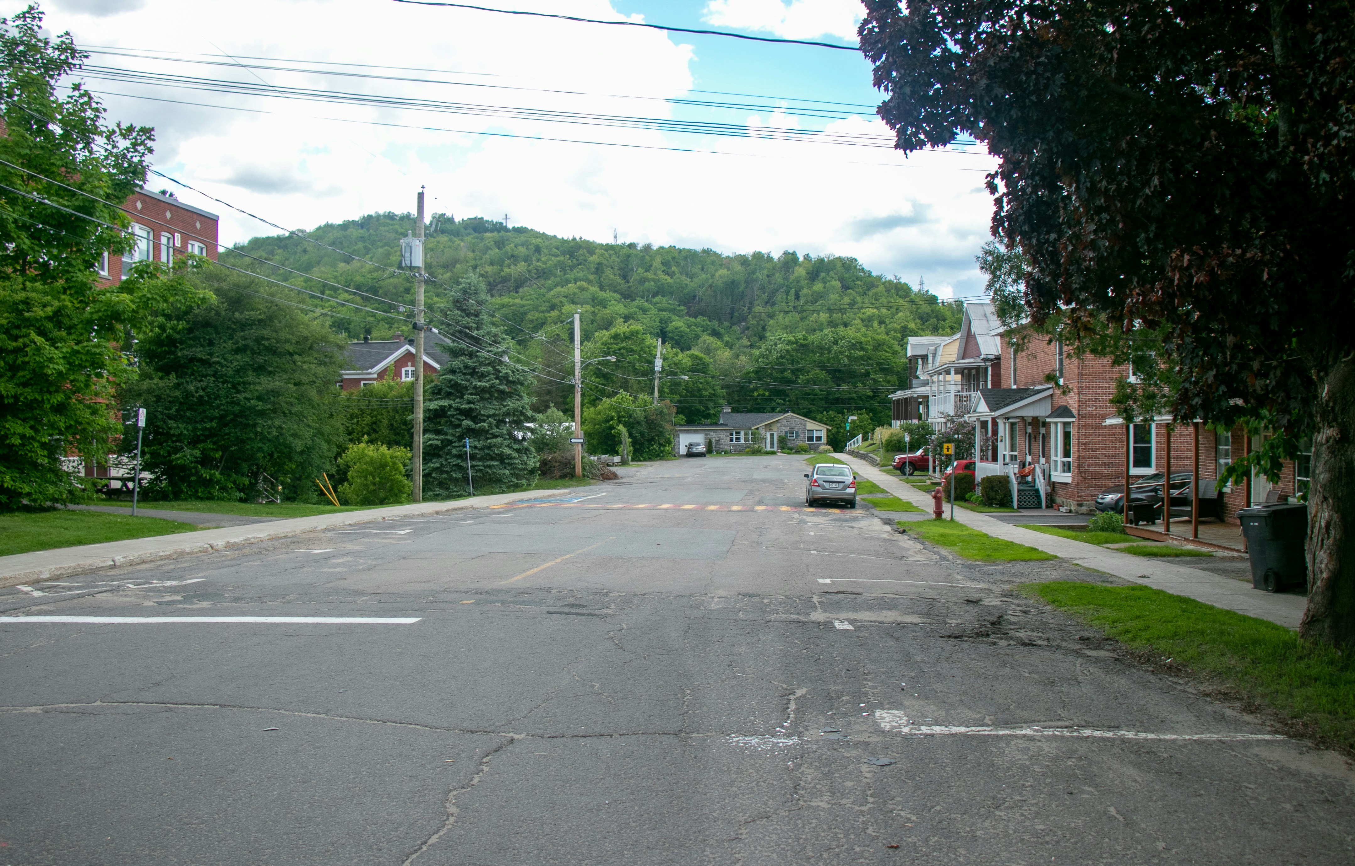 an empty street with a car parked on the side of it