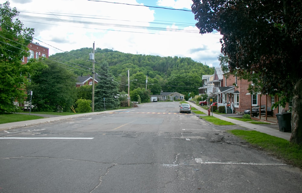 an empty street with a car parked on the side of it