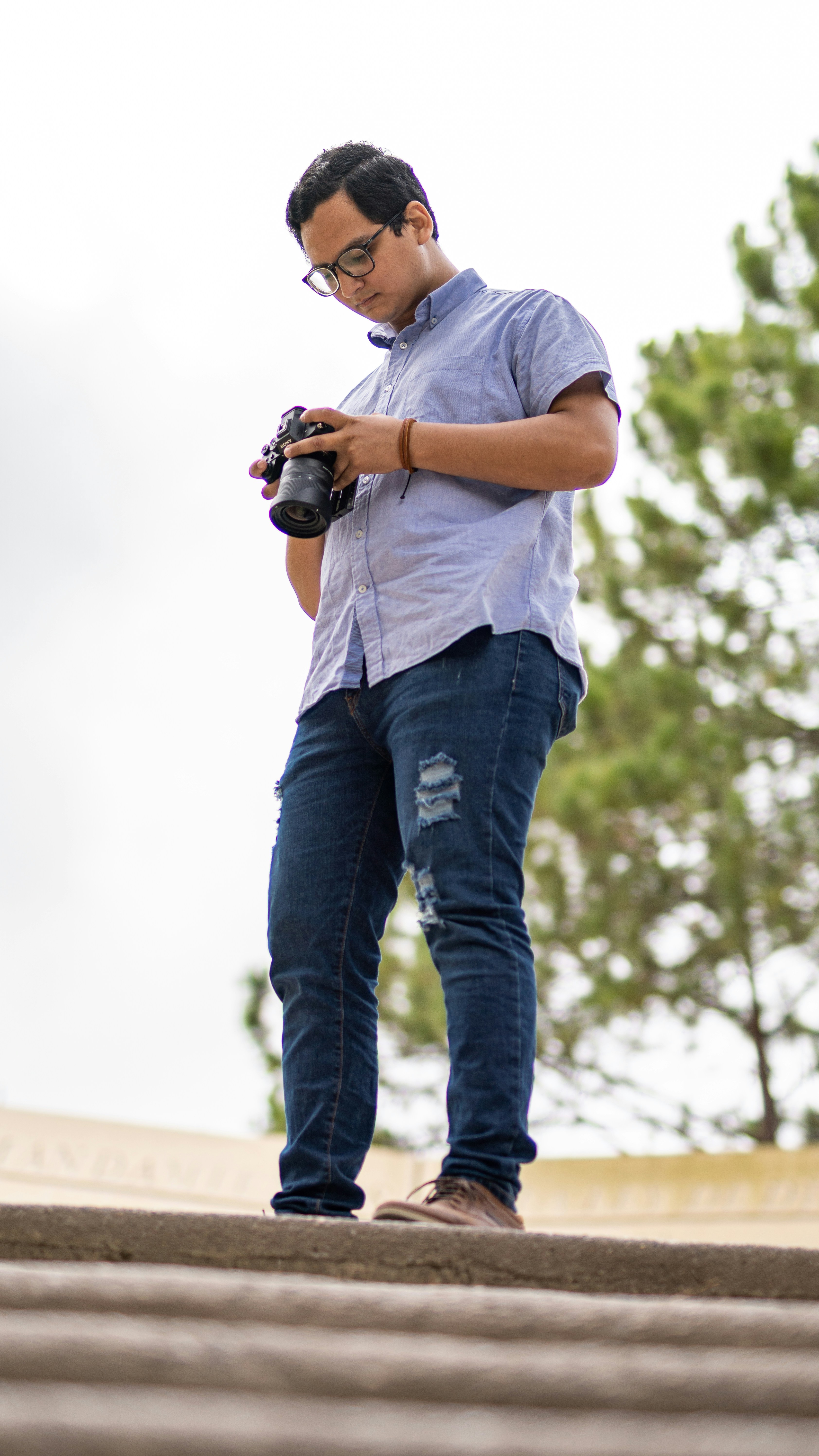 a man standing on top of a roof holding a camera