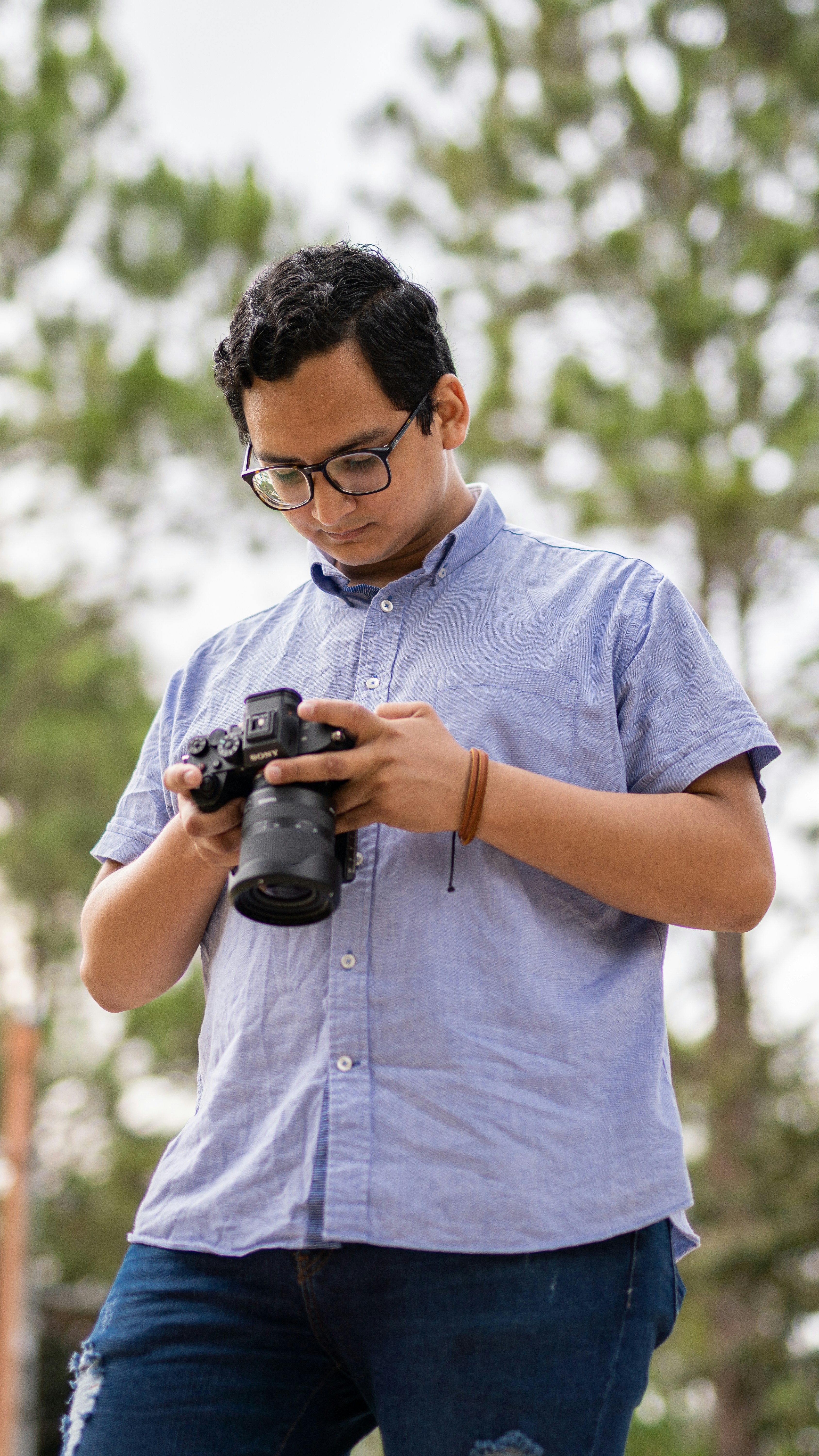 a man holding a camera and looking at it
