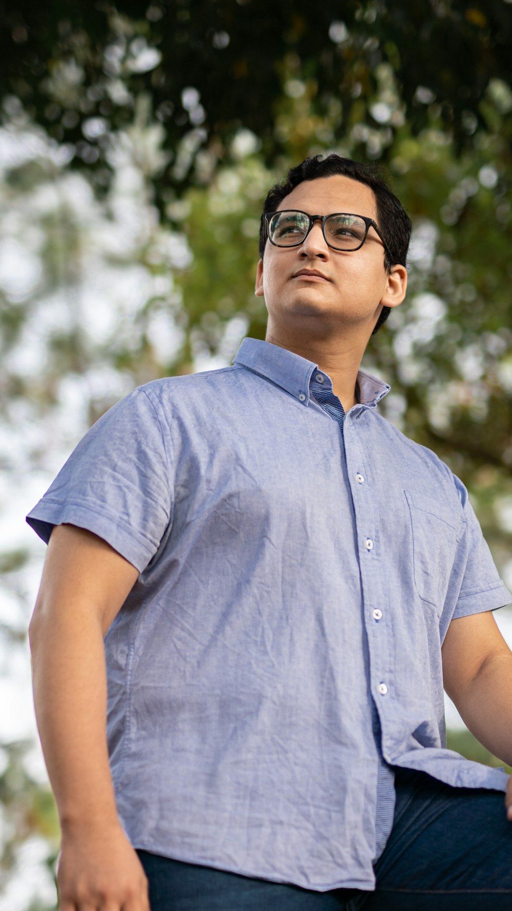 a man in a blue shirt is sitting on a bench