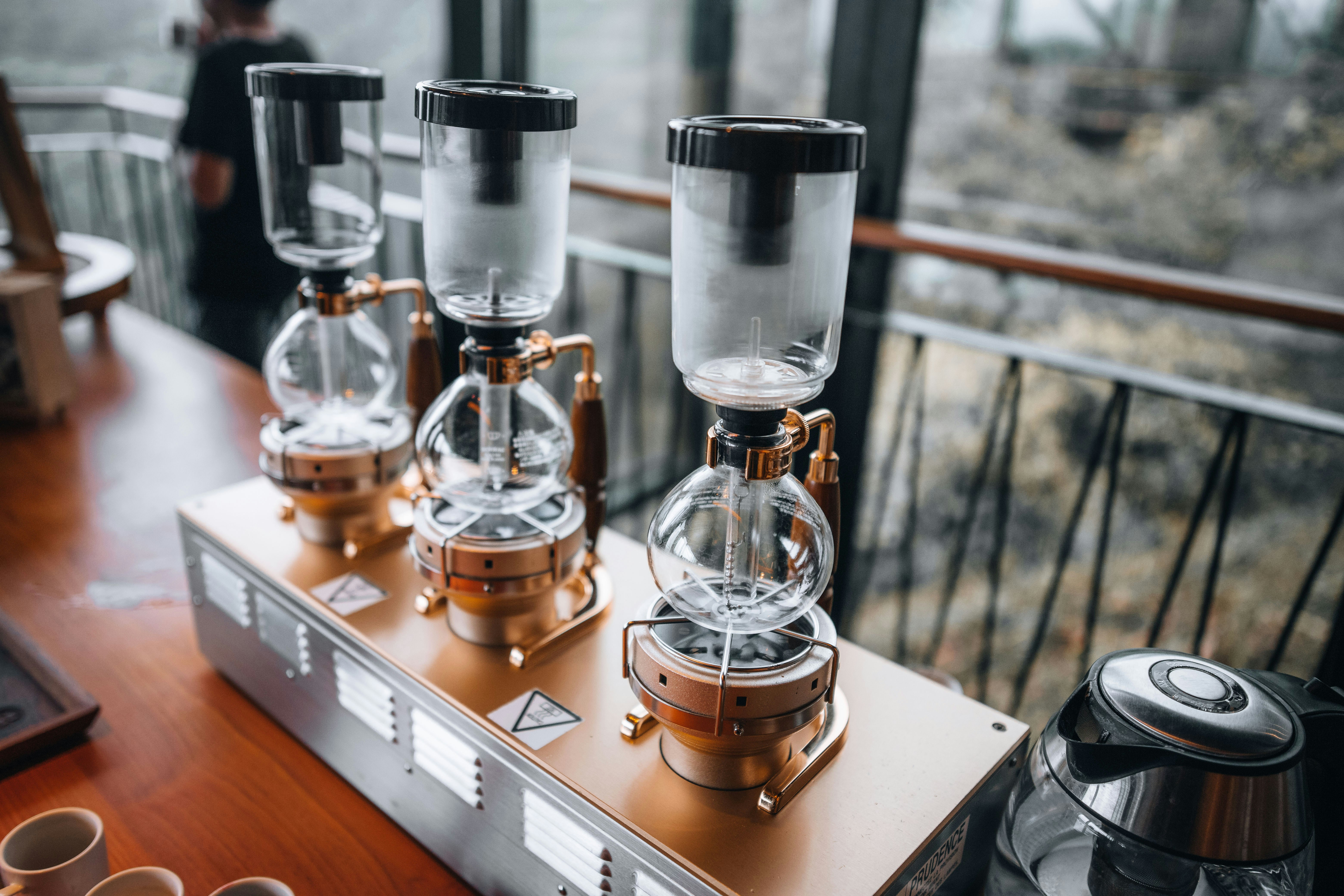 a group of coffee machines sitting on top of a wooden table