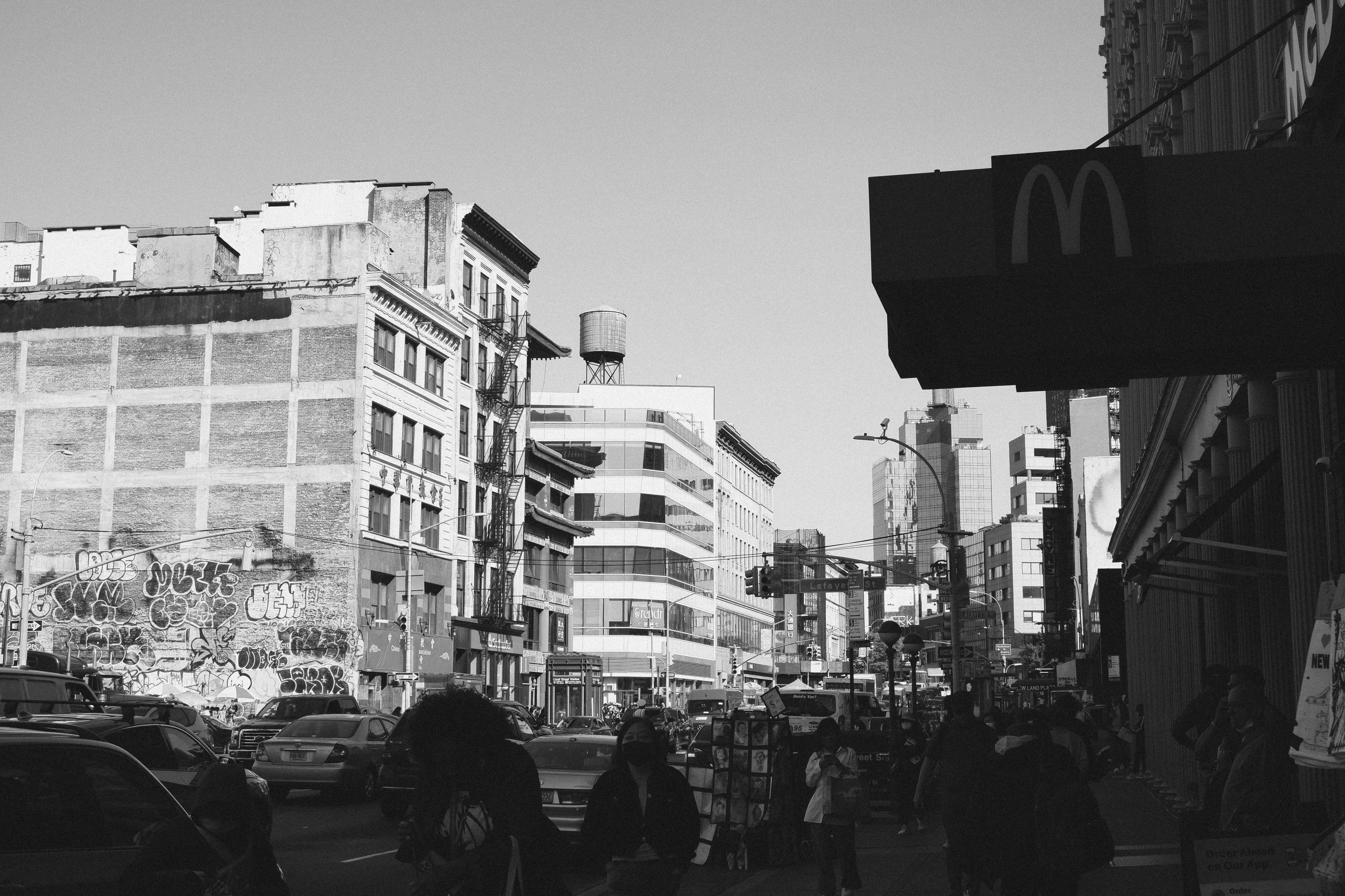 a group of people walking down a street next to tall buildings