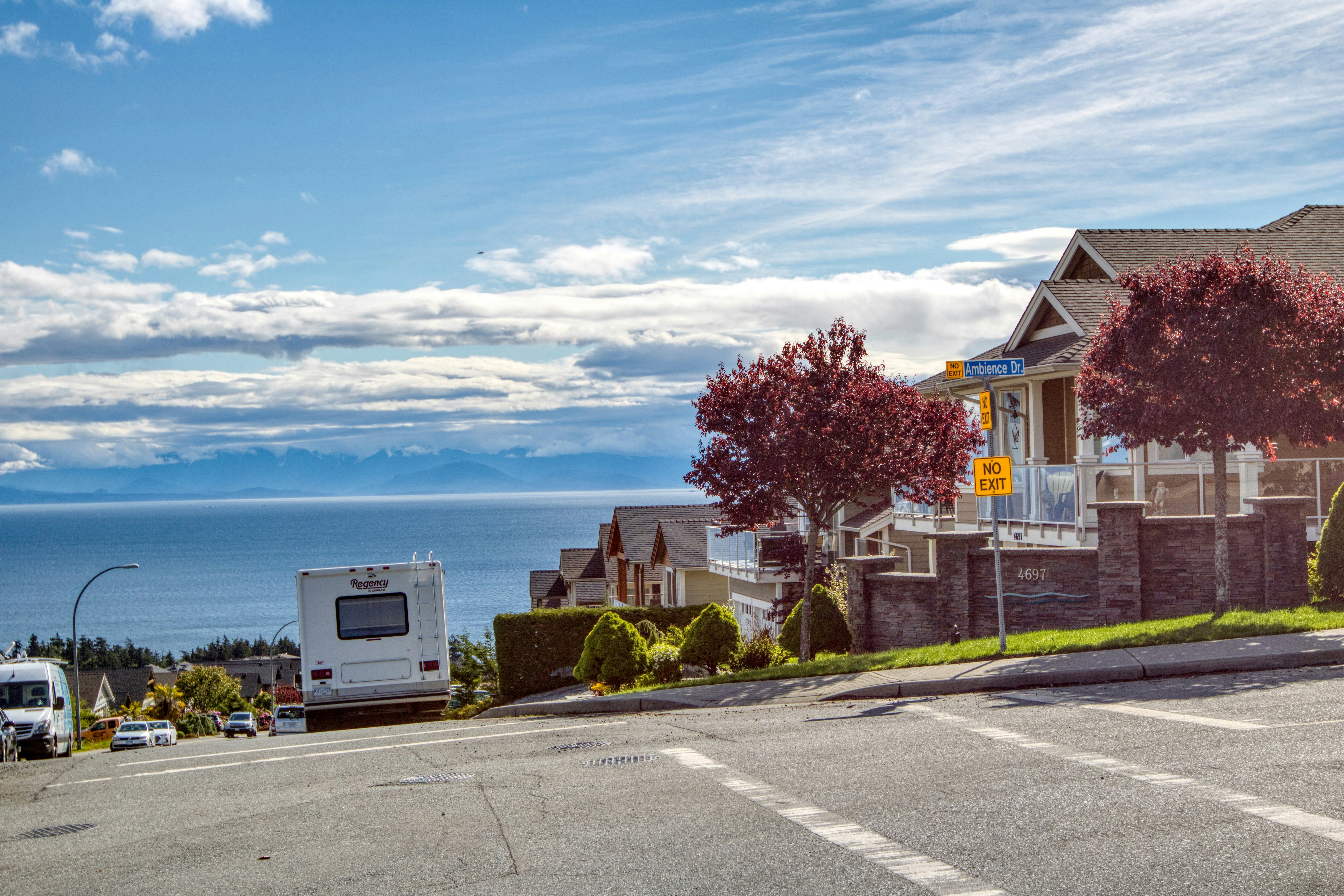 a view of a street with a car parked on the side of the road