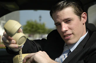 A friendly chauffeur answering a phone call in a sleek office setting.