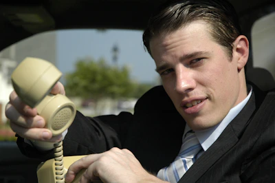 A friendly chauffeur answering a phone call in a sleek office setting.