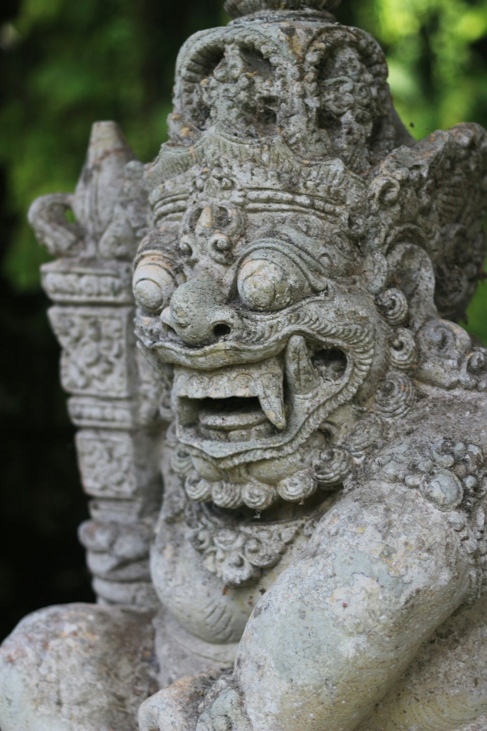 a stone statue of a demon with two heads
