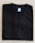 A neatly folded black T-shirt with a blue size label marked XL on a light-colored surface.
