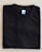 A neatly folded black T-shirt with a blue size label marked XL on a light-colored surface.