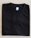 A neatly folded black T-shirt with a blue size label marked XL on a light-colored surface.