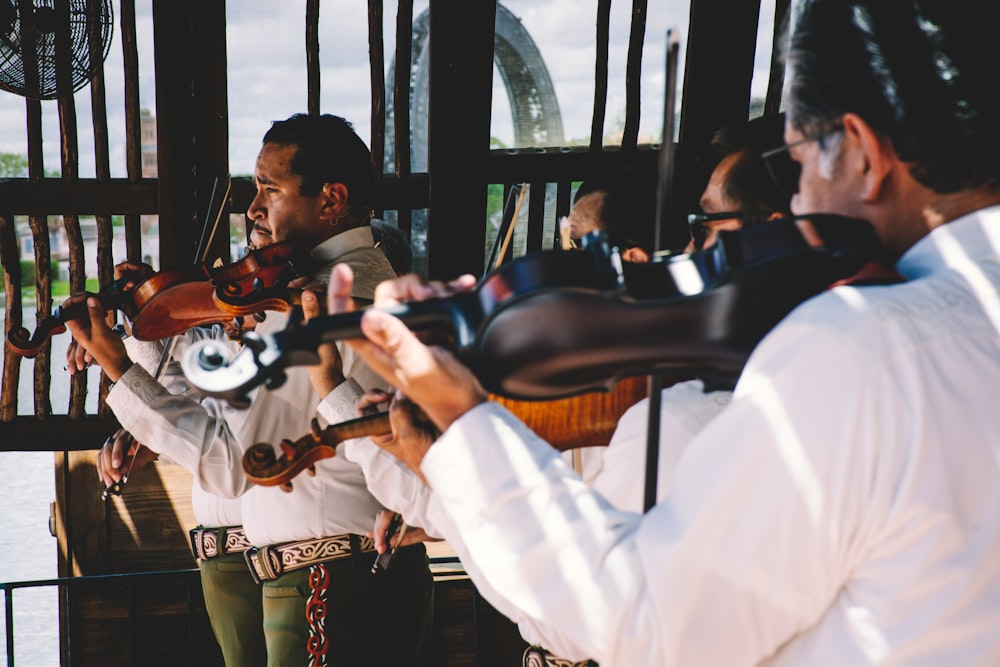 Un grupo de hombres tocando instrumentos musicales frente a una multitud