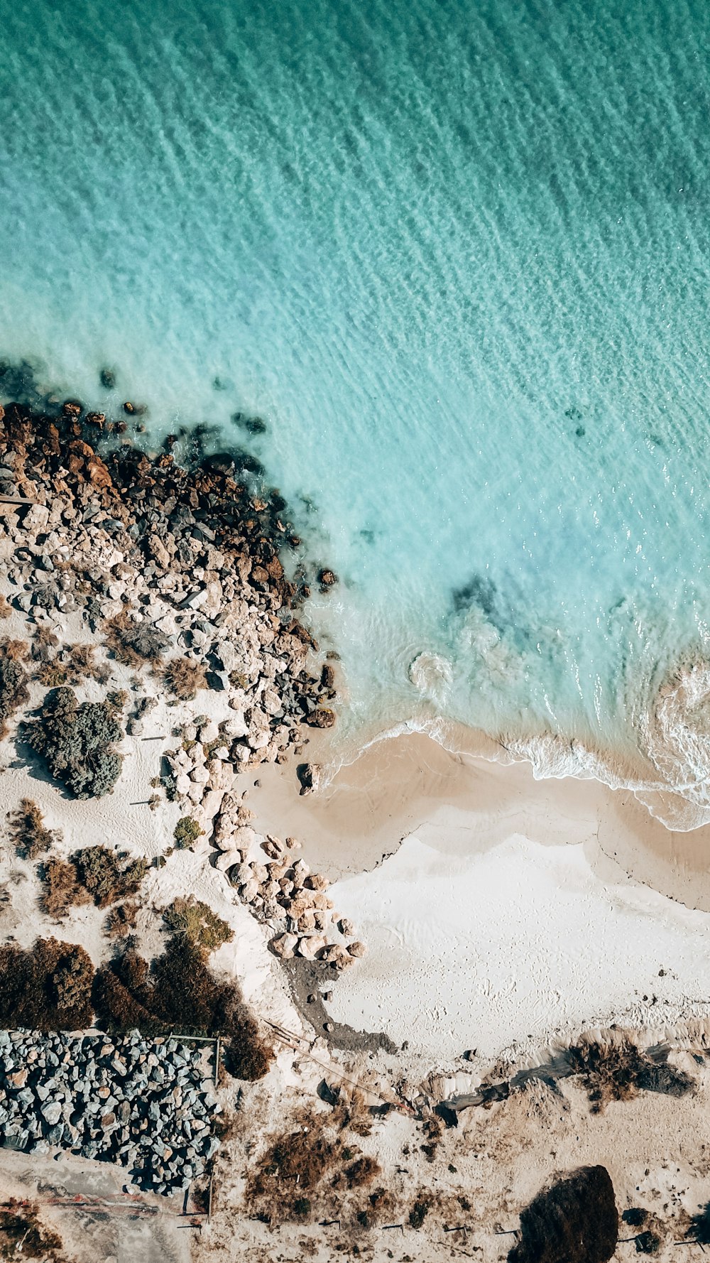 uma vista aérea de uma praia de areia e do oceano
