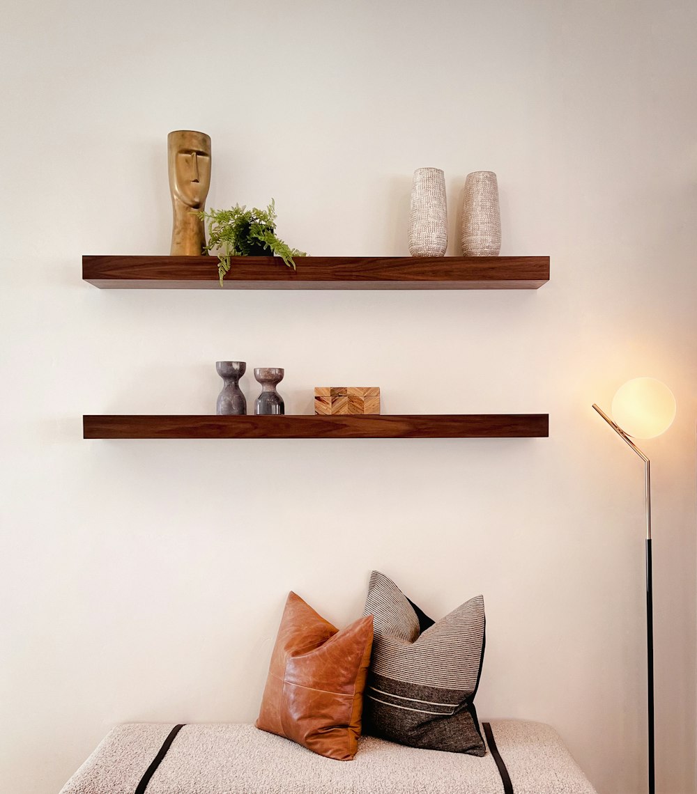 two floating shelves above a couch with pillows