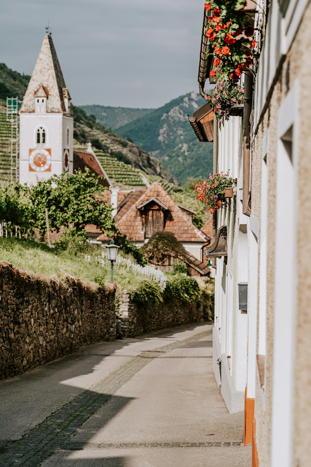 une rue étroite avec un clocher d’église en arrière-plan