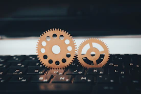 two wooden gears sitting on top of a keyboard