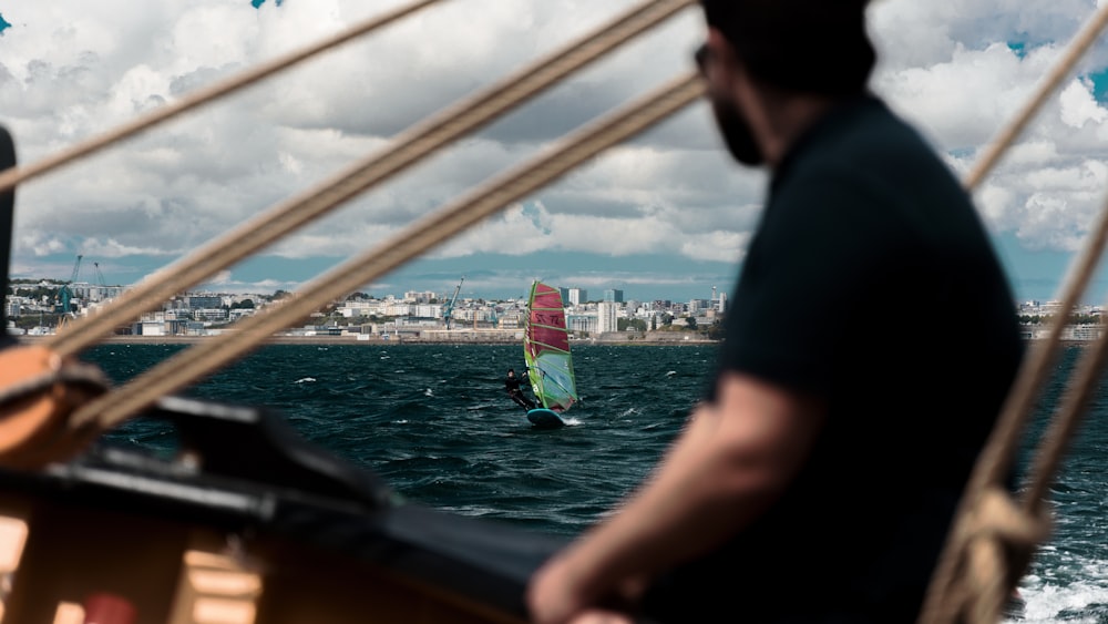 a man riding a sailboat on top of a body of water