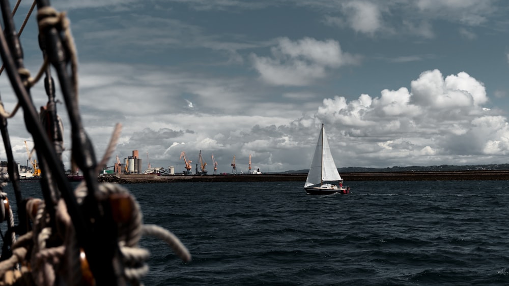 a sailboat in a body of water with a city in the background