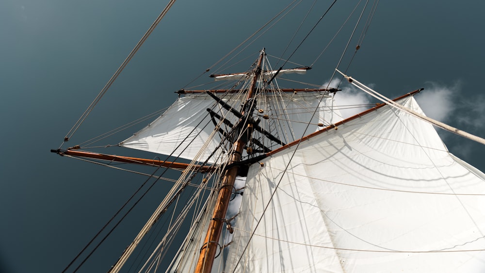 a white sail boat with masts against a blue sky