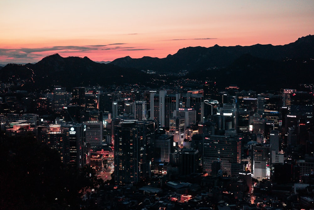 a view of a city at night with mountains in the background